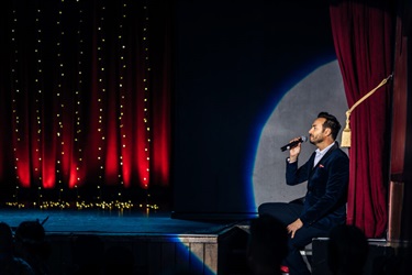 A person holding the microphone on stage